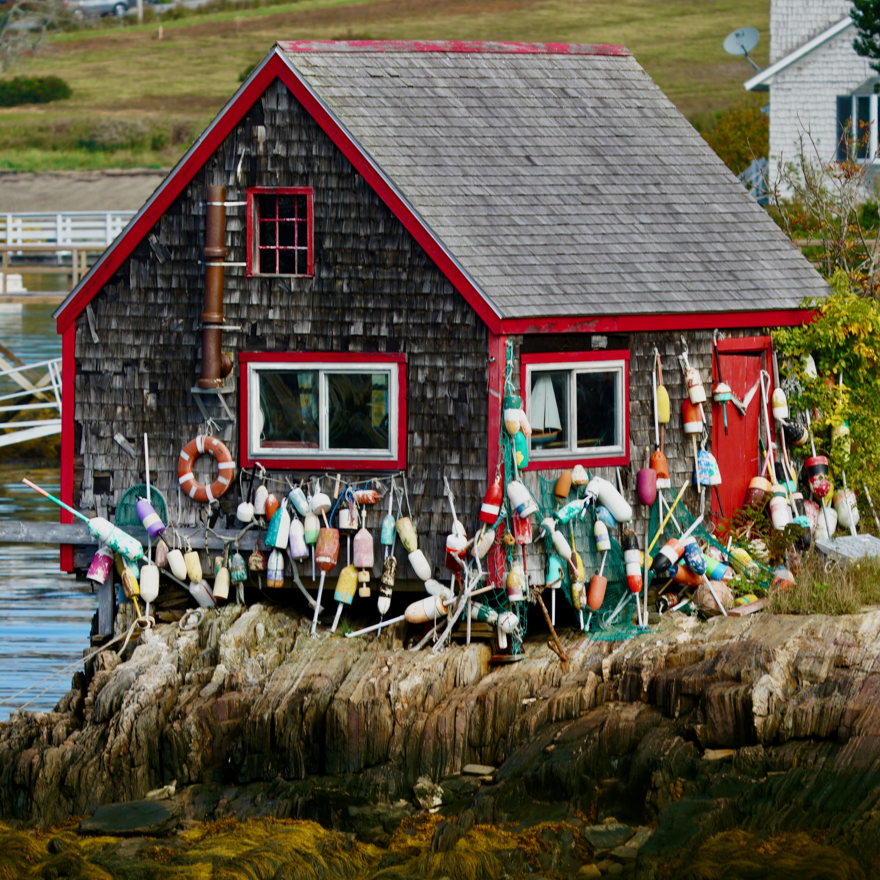 Coastal shack with colorful buoys along the shoreline